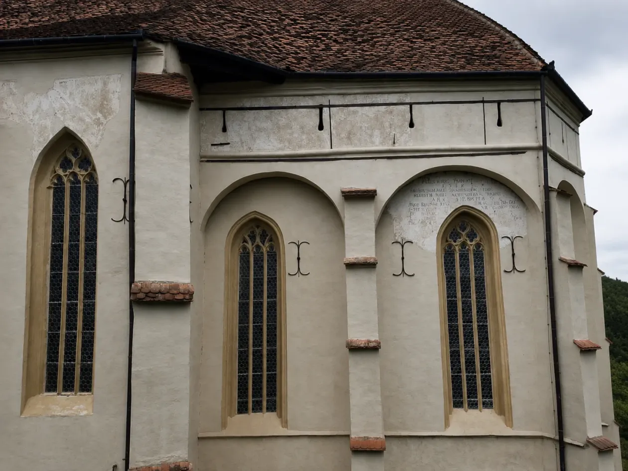 Külső kép: rések a templomfalon, ahonnan lőni is lehetett akár az ellenségre. Templombelső: a különlegesnek számító csavart oszlopok, amilyent csak itt, Szászmuzsnán láttunk – Fotó: a szerző archívuma