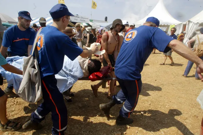 Mentők szállítanak el egy a hőség miatt rosszul lett férfit a Larzac 2003 elnevezésű globalizációellenes tüntetésről, 2003. augusztus 9-én – Fotó: Eric Cabanis / AFP