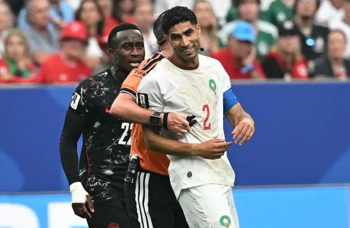 Michael Oliver játékvezető rángatja félre a kanadai Richie Laryeával kakaskodó Ásraf Hakimit. Fotó: Paul Ellis / AFP or licensors