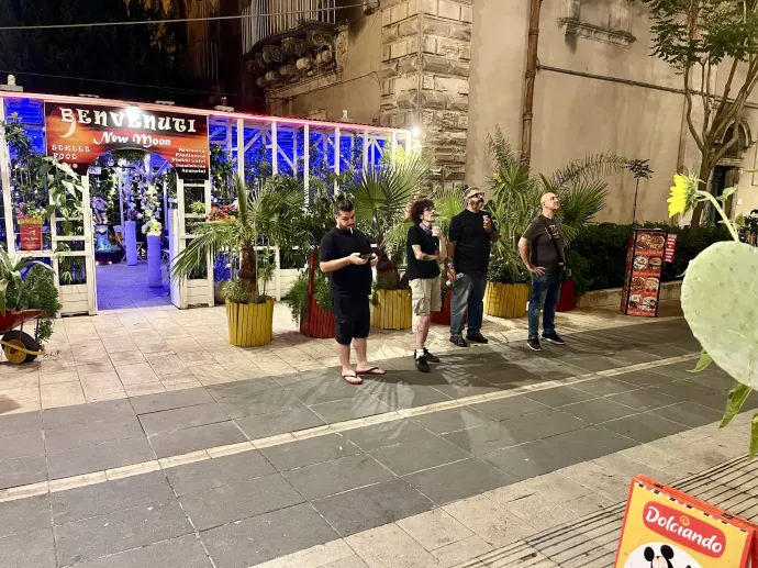 Pár járókelő nézi a Franciaország–Spanyolország-meccset a szicíliai Ragusa főutcáján – Fotó: Bakró-Nagy Ferenc / Telex