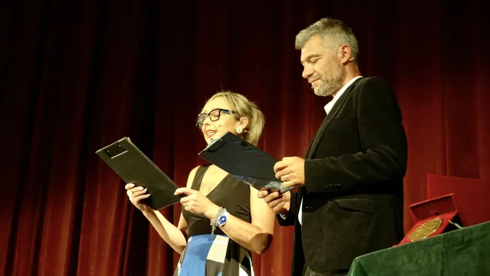Kelemen Hunor beszédét bújja a kezdés előtt, mellette Oláh Emese alpolgármester és Csoma Botond képviselő. A gála műsorvezetői: Forrai Szerénke és Farkas Lóránd – Fotók: Kiss Botond / Transtelex