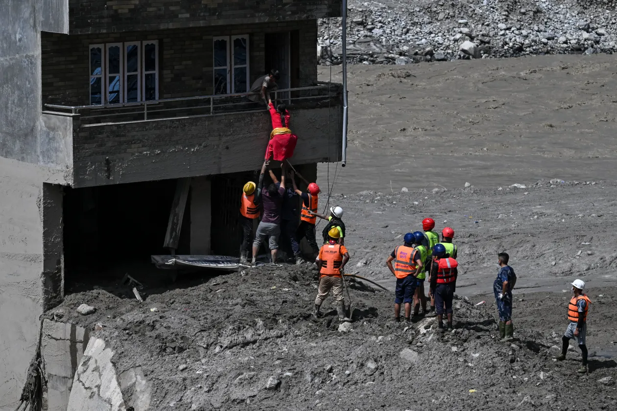 Embereket mentenek az áradás után – Fotó: Navesh Chitrakar / Reuters – Arun Sankar / AFP