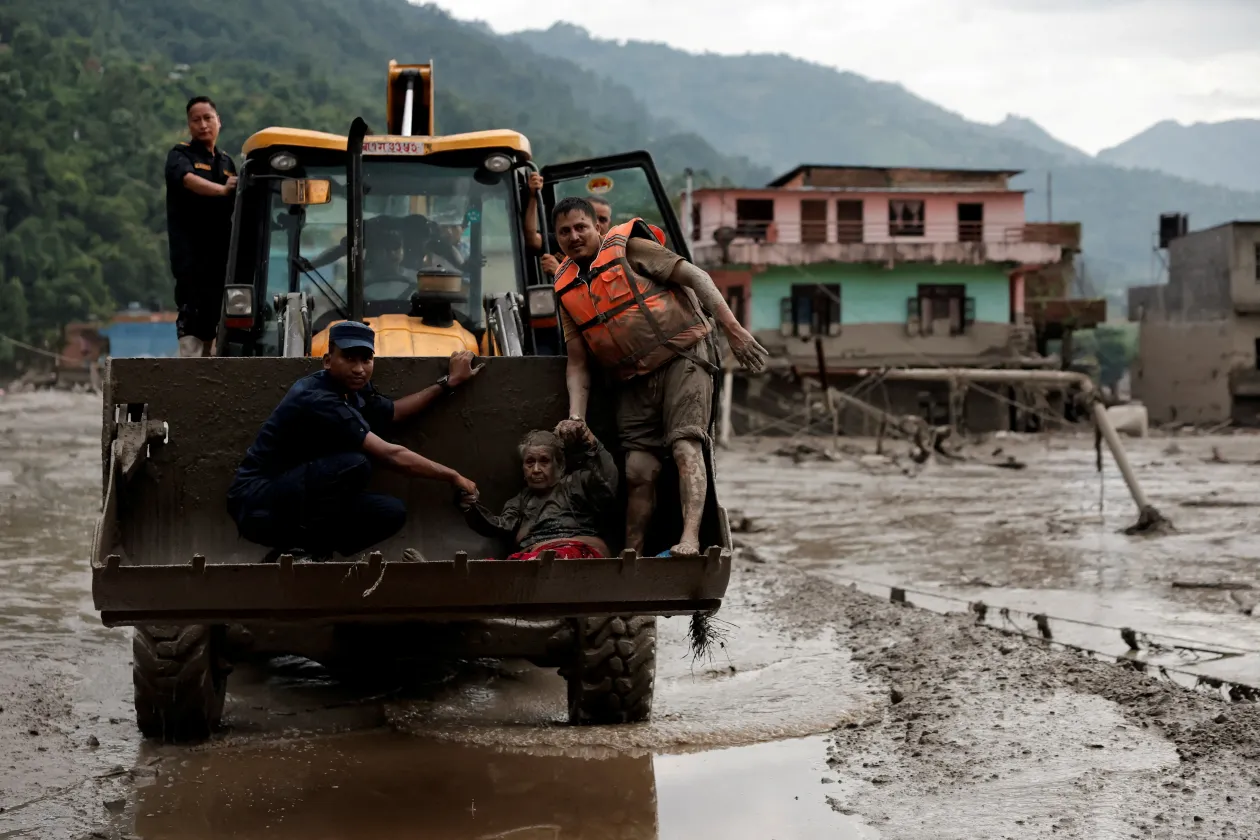 Embereket mentenek az áradás után – Fotó: Navesh Chitrakar / Reuters – Arun Sankar / AFP
