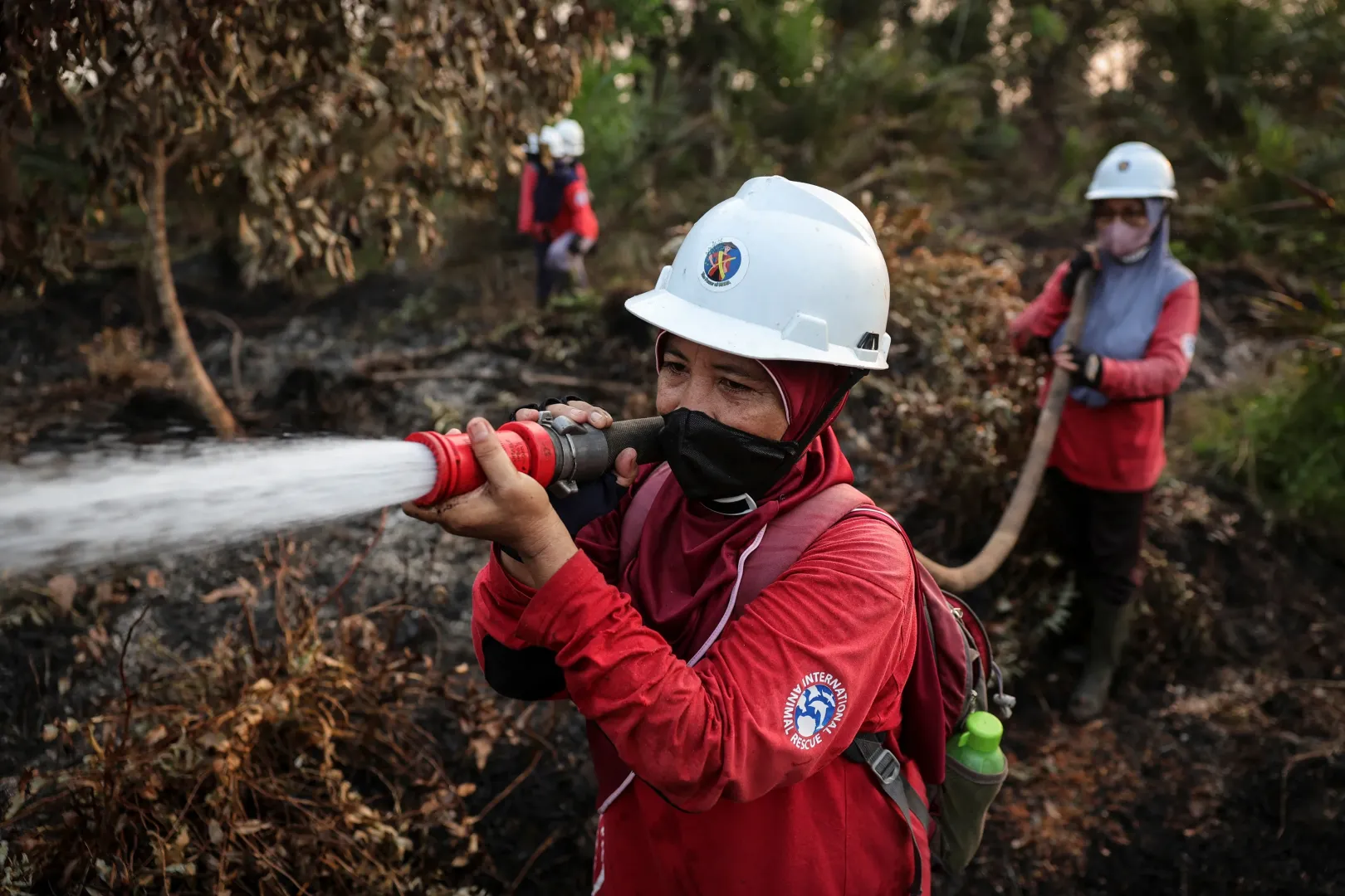 A 48 éves Juniarni a faluja, Sungai Awan Kiri közelében oltja a tüzet – Fotó: Willy Kurniawan / Reuters