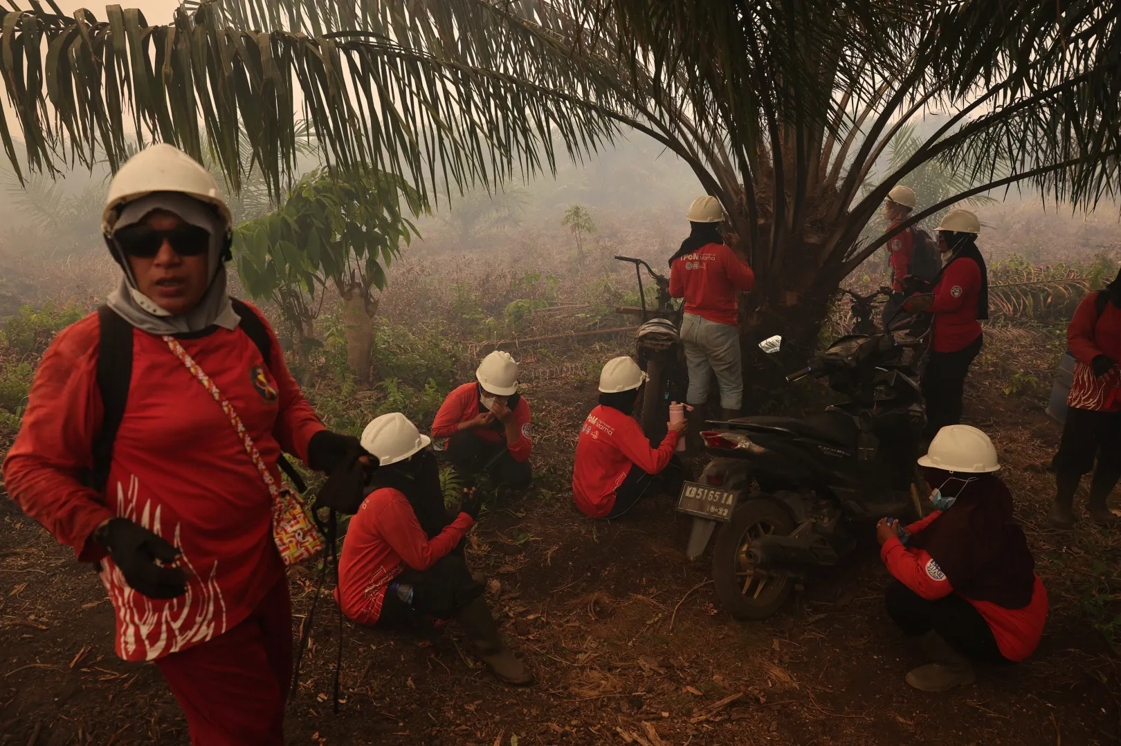 A The Power of Mama önkéntes tűzoltó csoport tagjai szünetet tartanak oltás közben egy pálmaolaj-ültetvényen – Fotó: Willy Kurniawan / Reuters