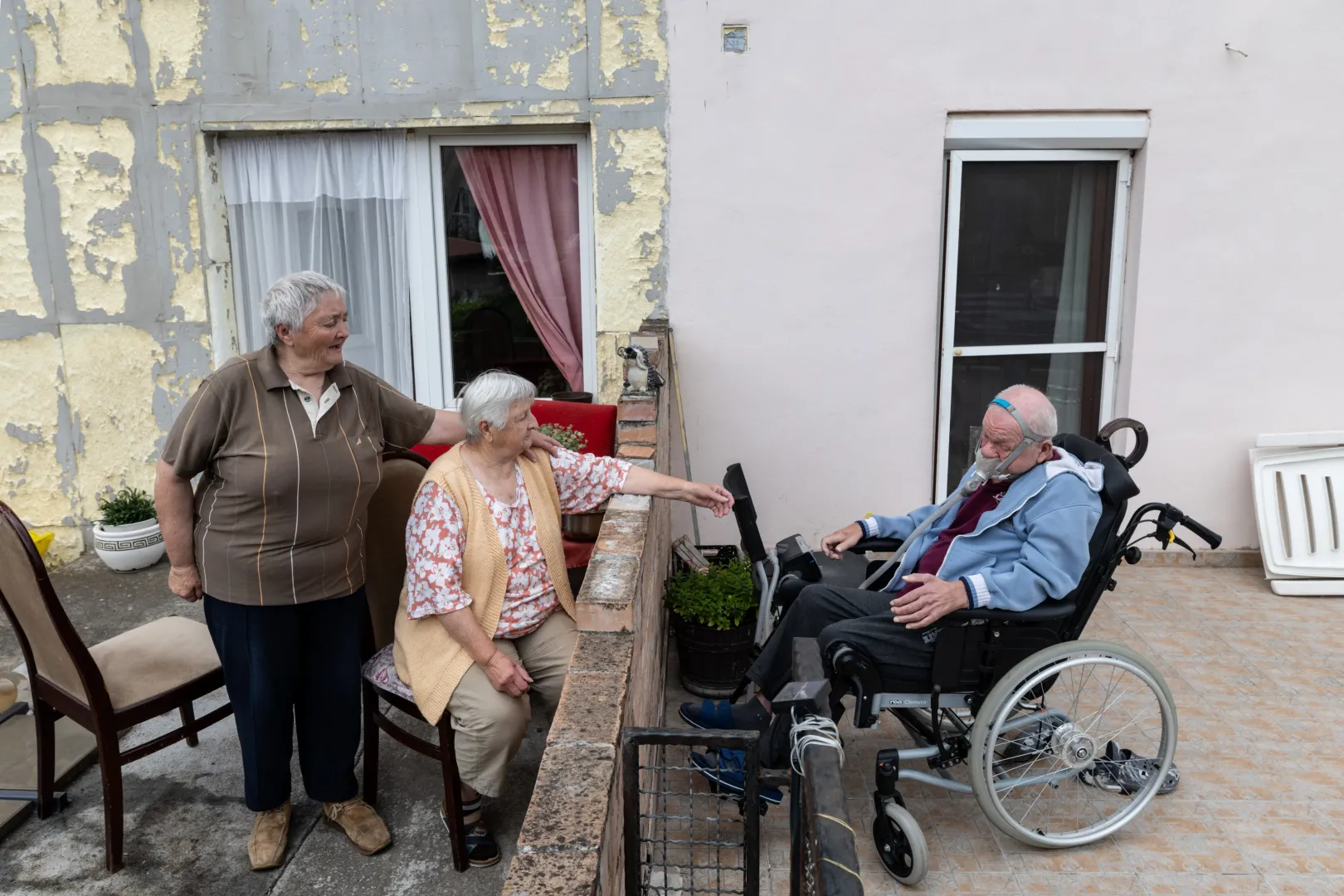 Béla szomszédjában lakó édesanyja nyújtja a kezét fia felé